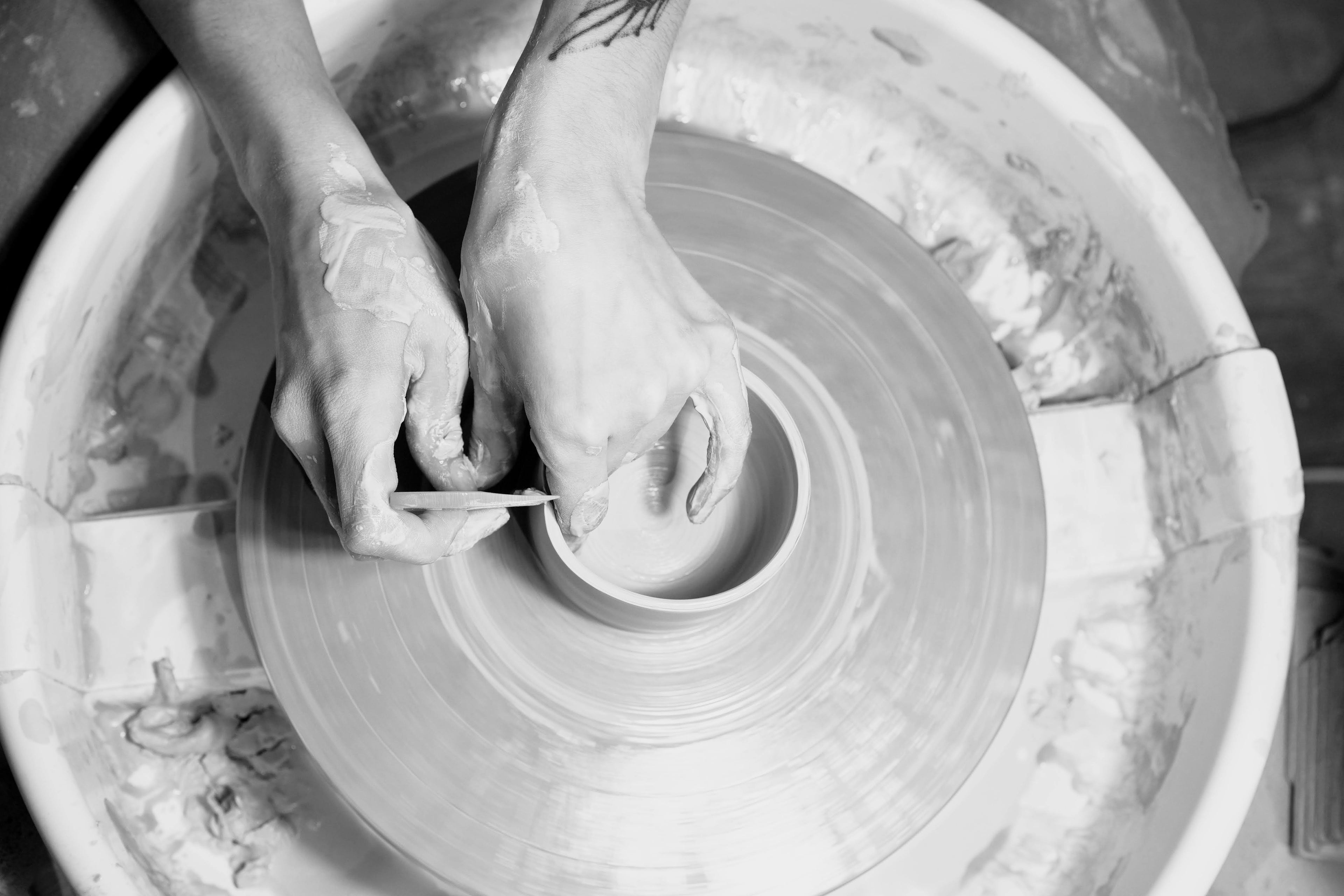 Person working with clay on a pottery wheel