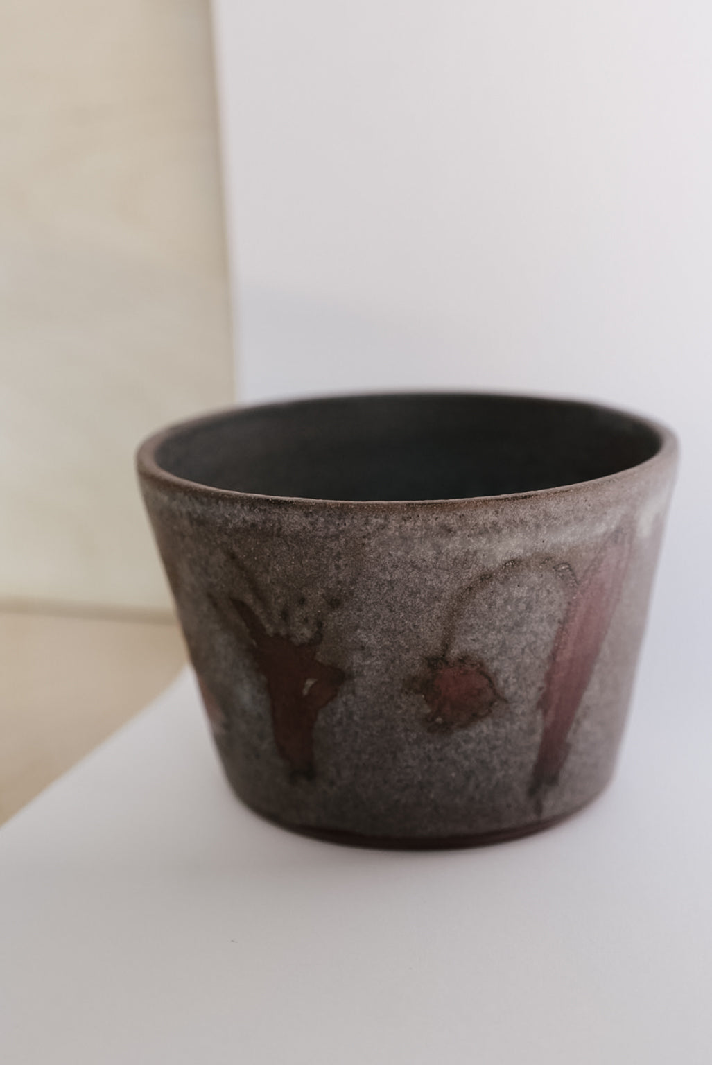 Ceramic cup with speckled design on a white surface