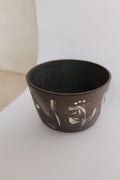 Ceramic cup with white designs on a light background