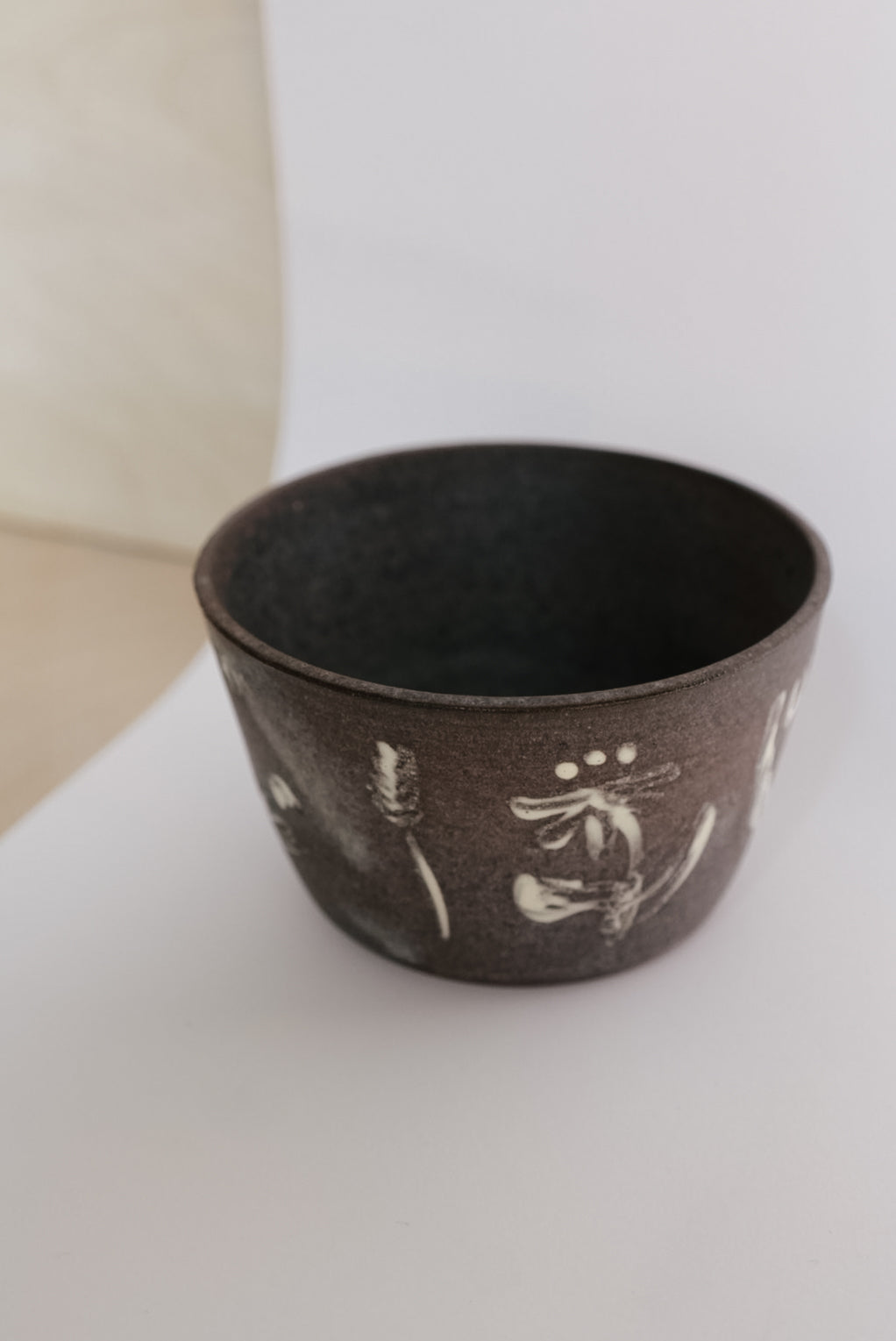 Ceramic cup with white designs on a light background