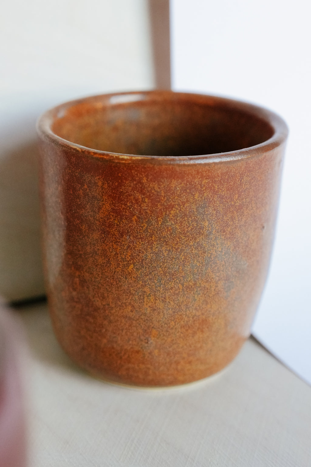 orange ceramic cup on a white surface
