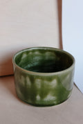 Green ceramic cup on a neutral background