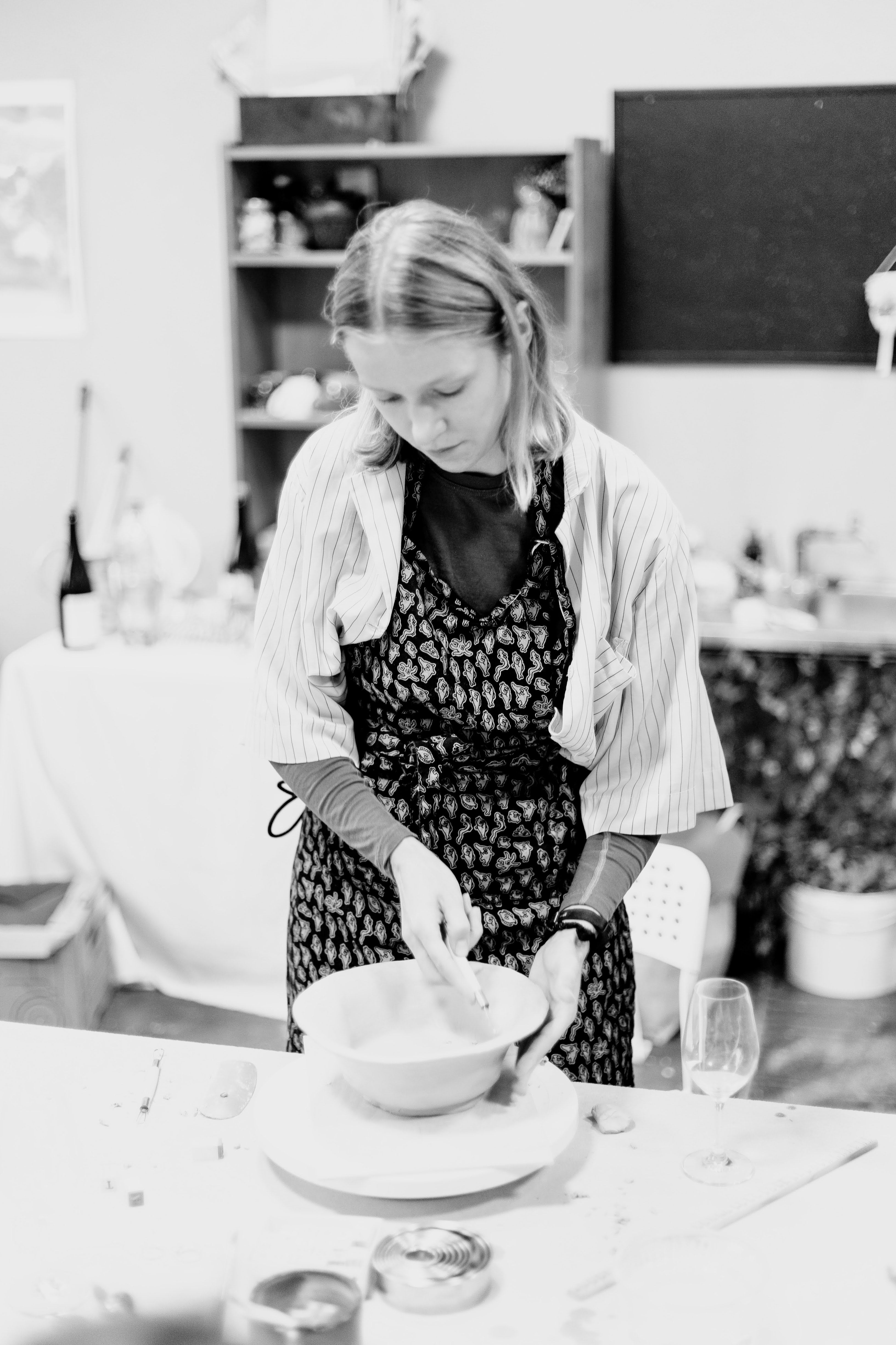 Person working with pottery on a wheel in a studio setting